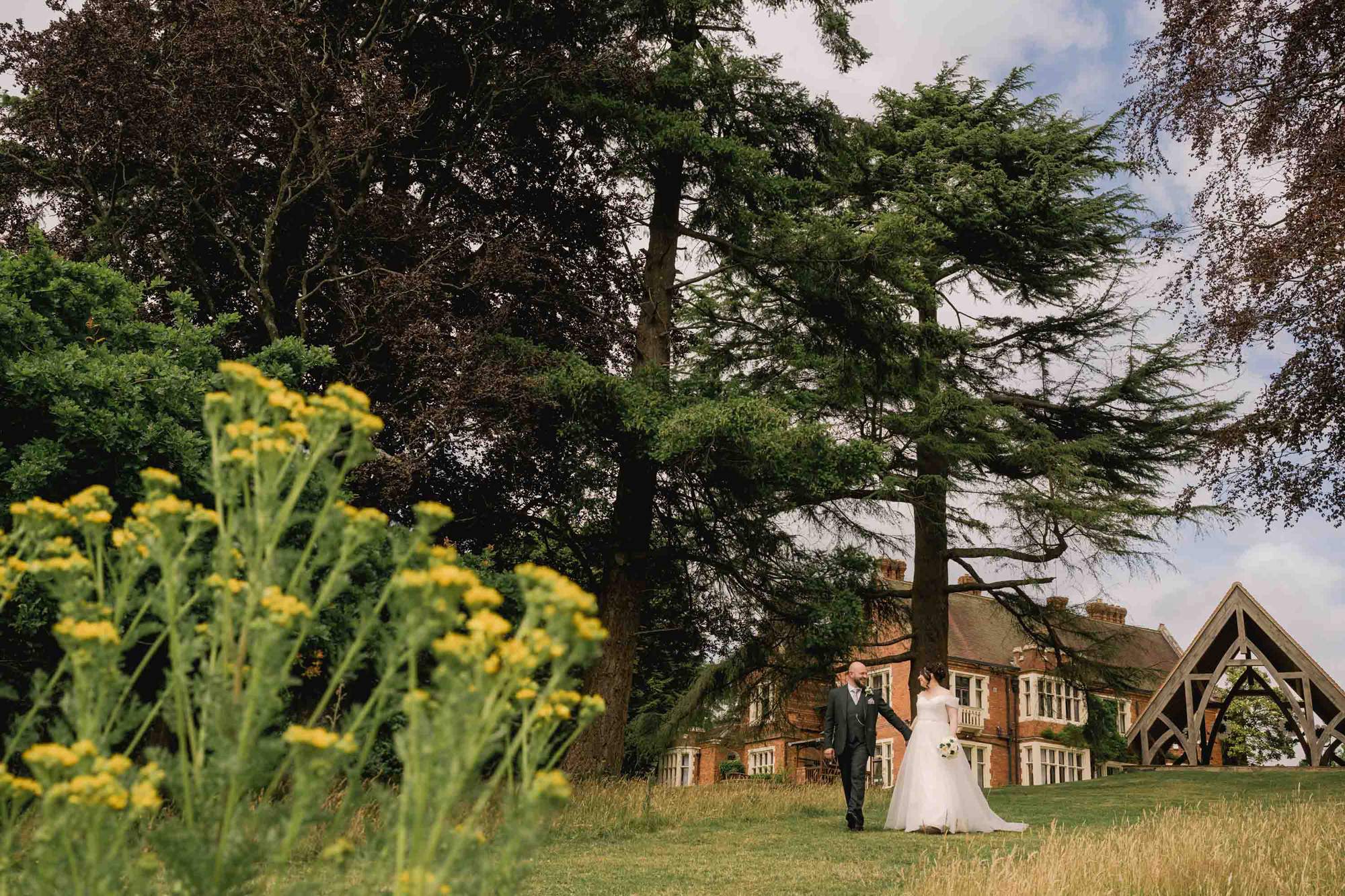 Bride and groom taking a stroll on their wedding day at Highley Manor in Sussex.