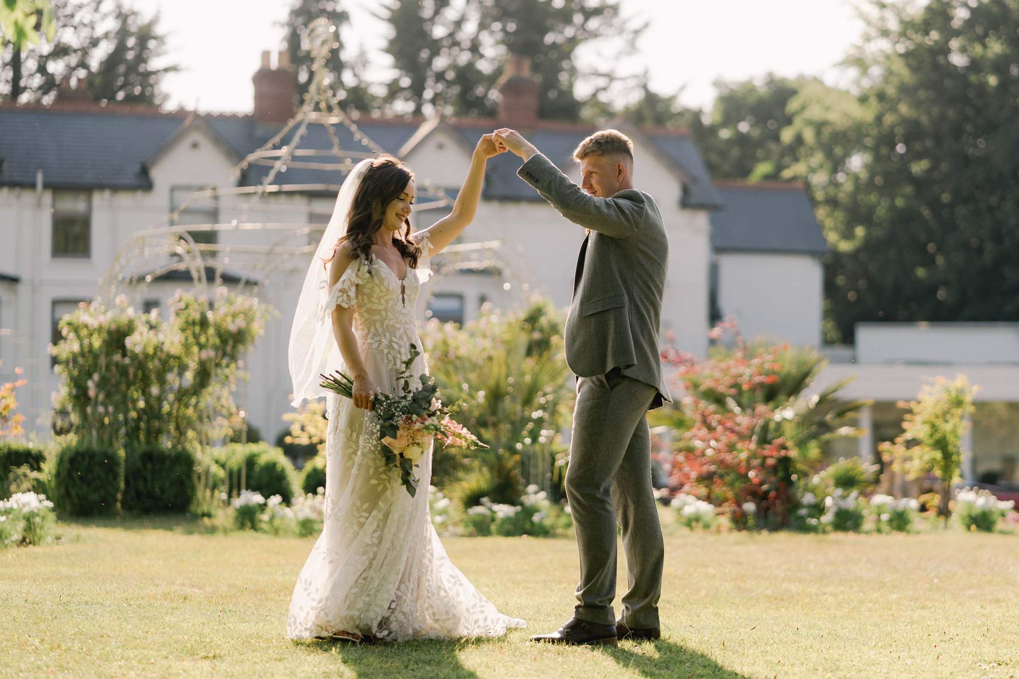 Bride and groom practice their first dance together on their wedding day with the Southdowns Manor hotel as the backdrop.