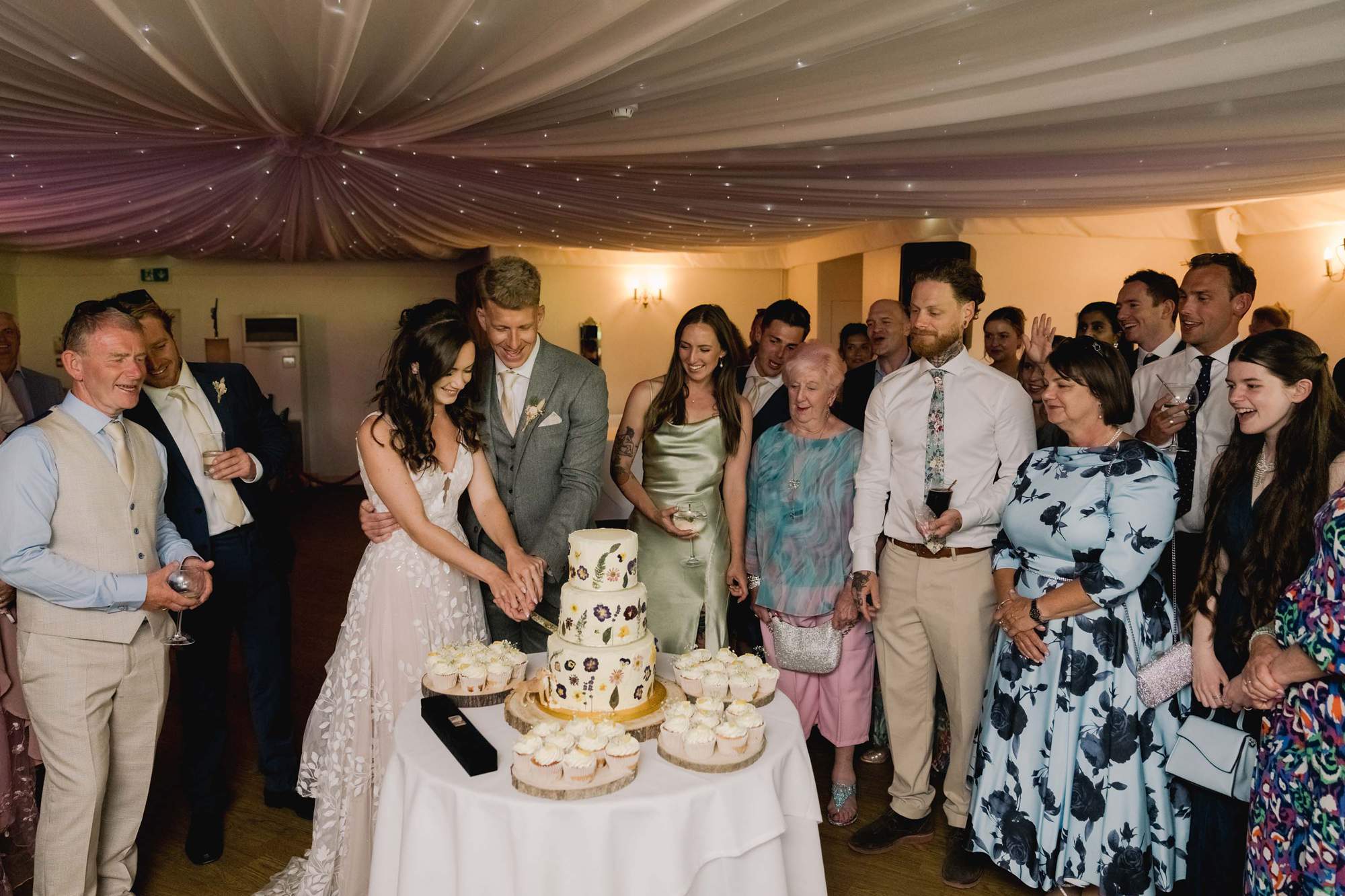 Bride and groom cut the cake together on their wedding day at Southdowns Manor in the National Park.