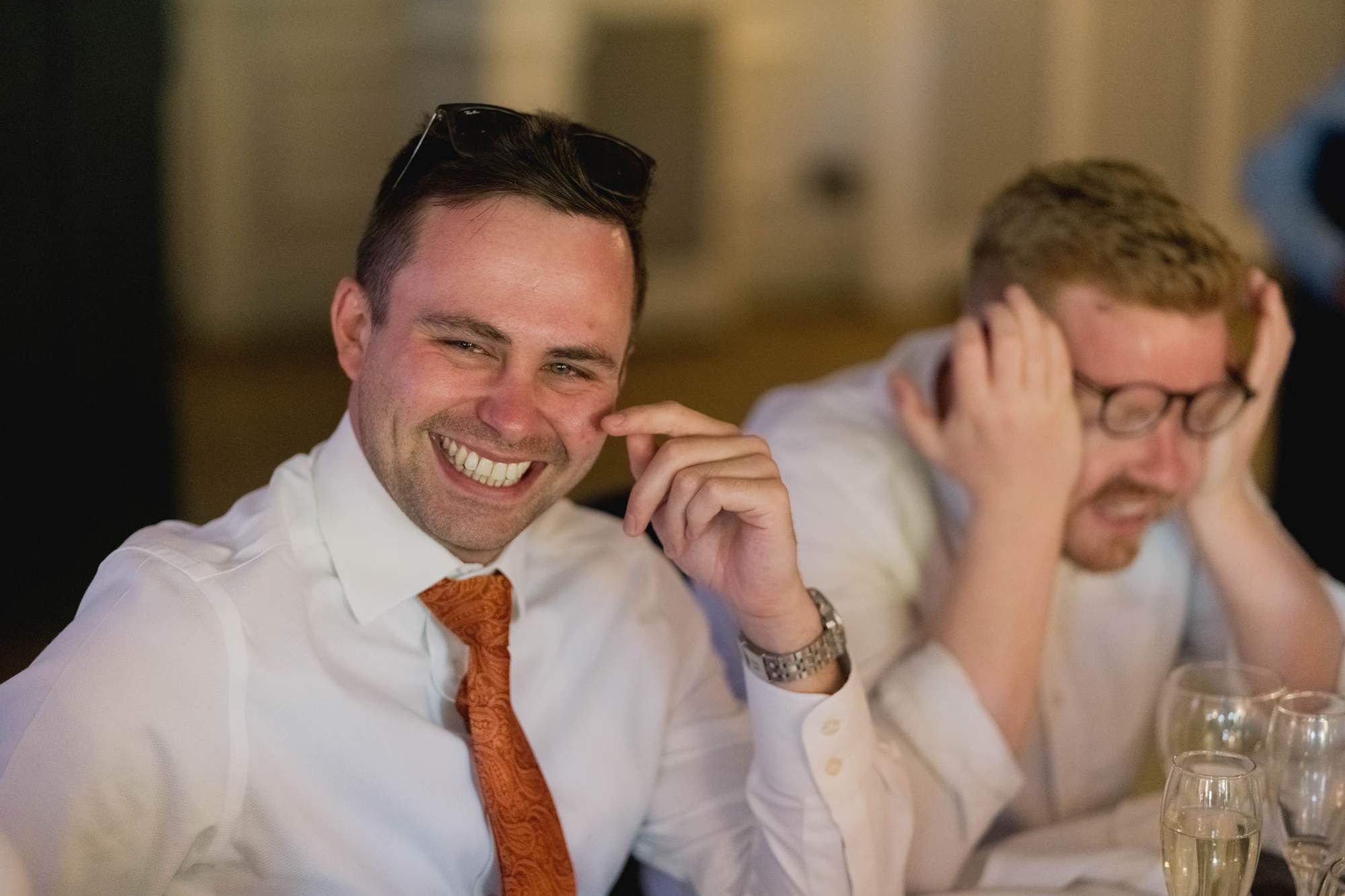 A guest laughing at a wedding.