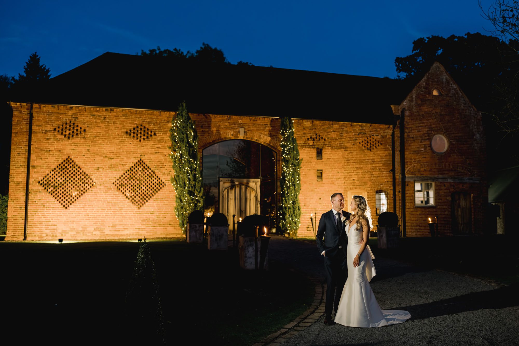 Bride and groom stare lovingly in to each other's eyes under a twilight sky on their wedding day at Shustoke Barn.
