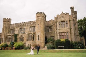 Bride and groom take a stroll on their wedding day at Wadhurst castle in Sussex.