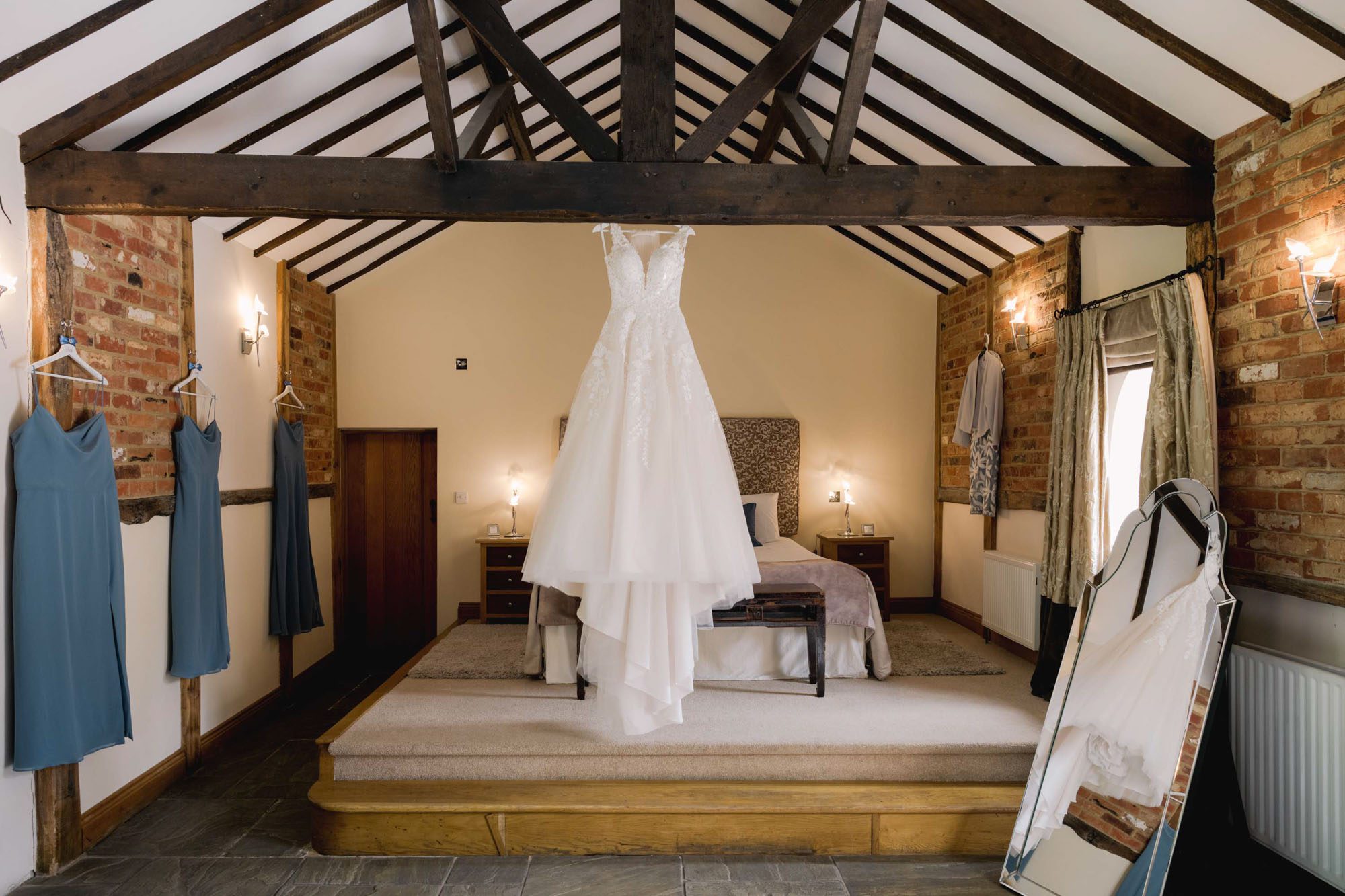 Wedding dress hung on the beams at Rivervale Barn in Hampshire.