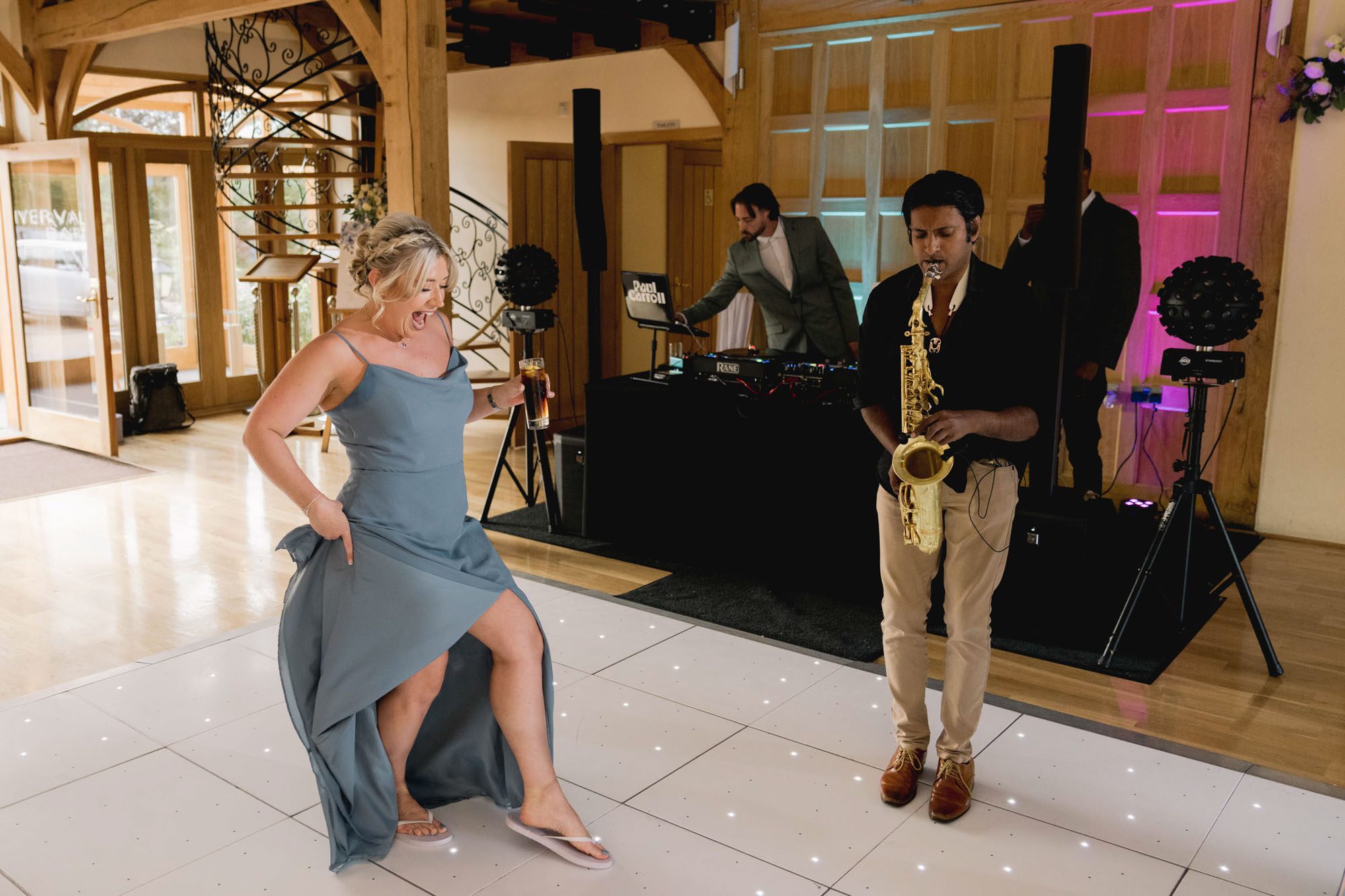 A guest dancing on the dance floor at a wedding at Rivervale Barn in Hampshire.