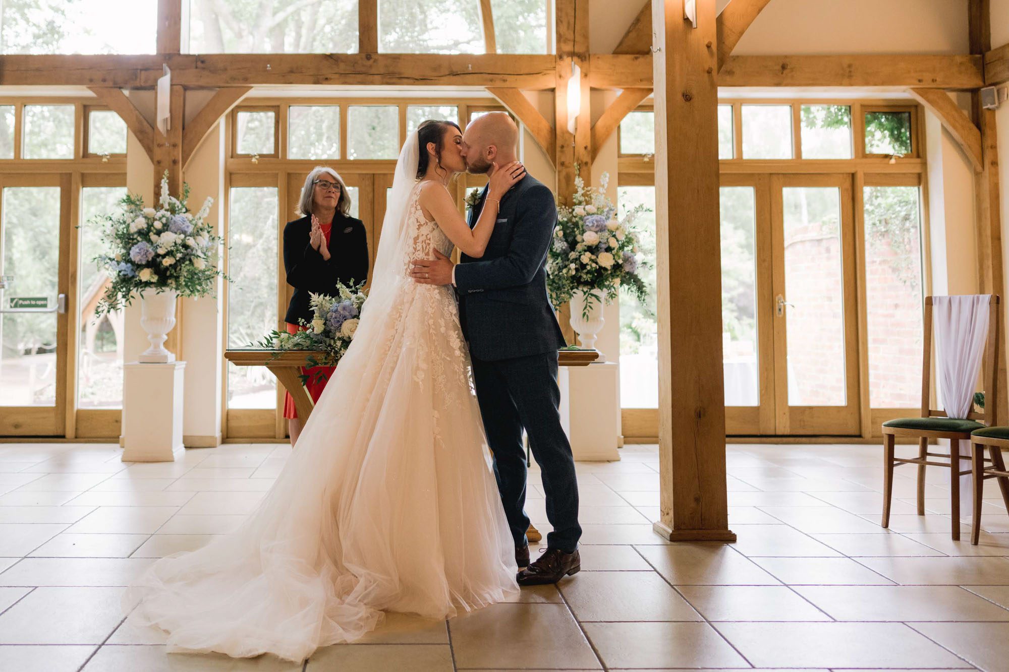 Bride and groom kiss on their wedding day during the ceremony at Rivervale Barn in Hampshire.