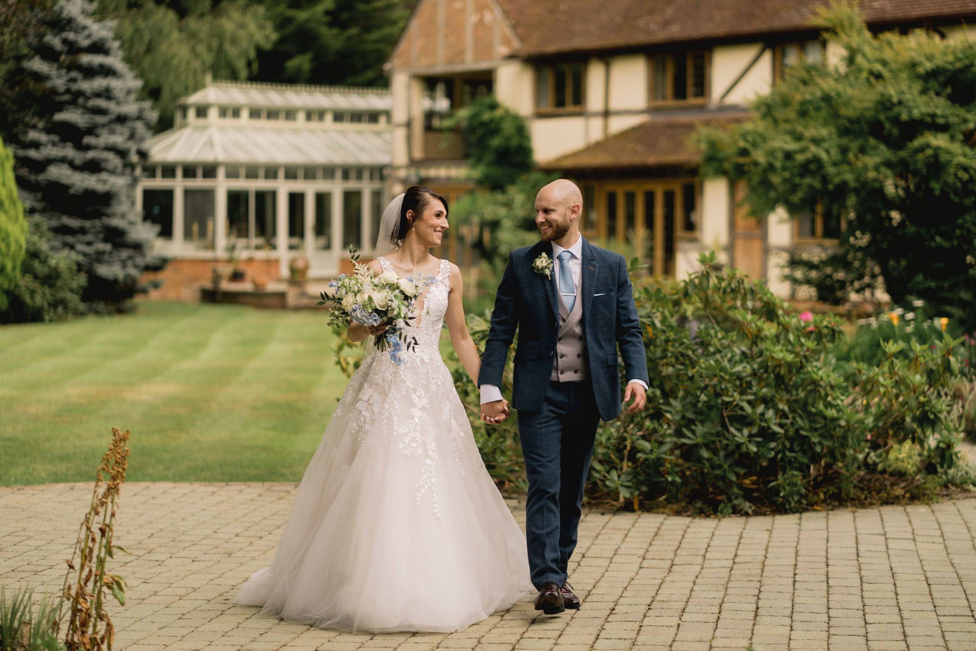Bride and groom hold hands on their wedding day at Rivervale Barn in Hampshire.