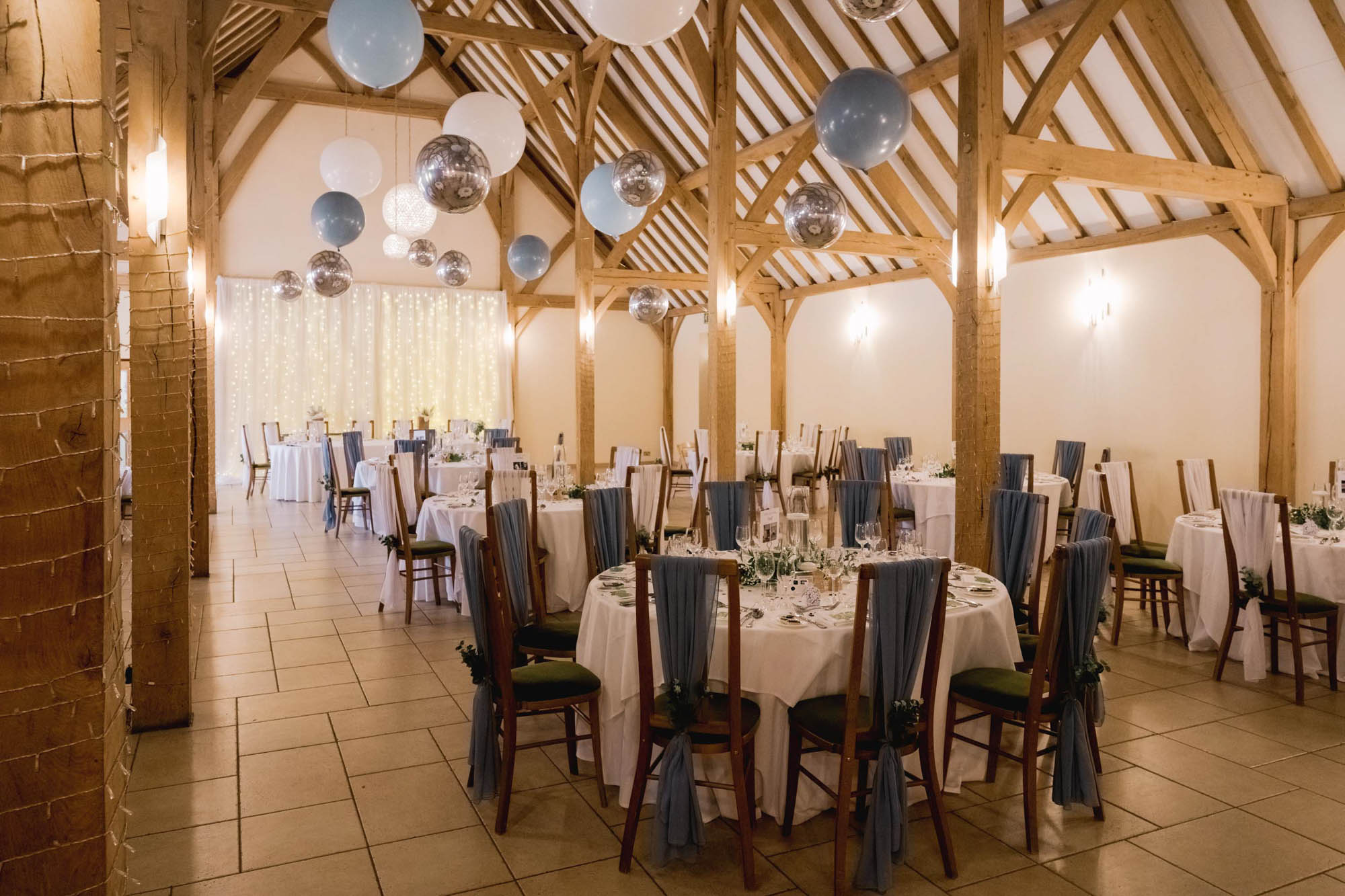 Wedding breakfast tables and chairs in the barn at Rivervale Barn in Hampshire.